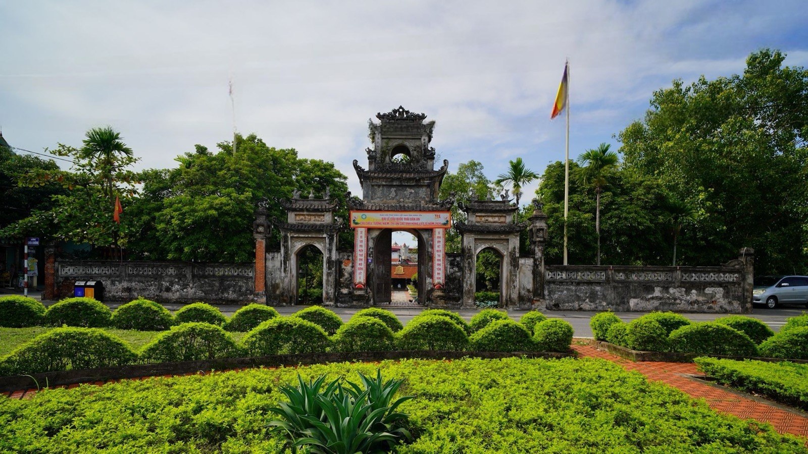 Cổng Tam quan chồng diêm nhìn từ vườn cây phía trước chùa.